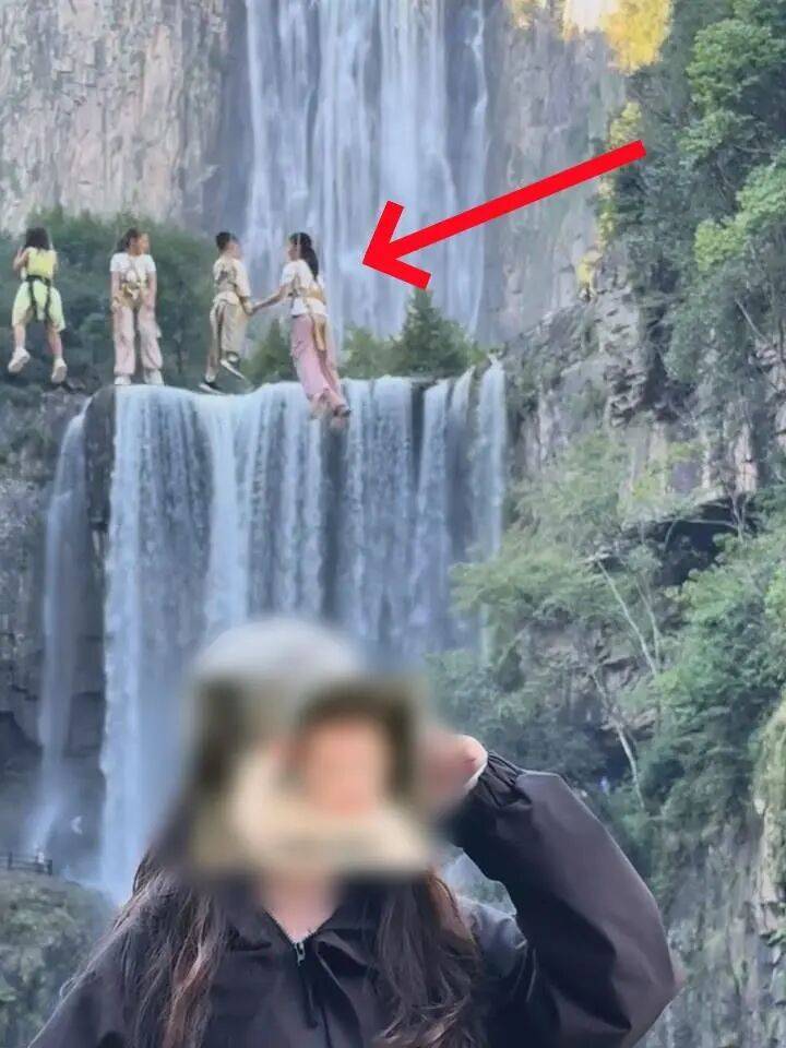 女生瀑布前拍视频,空中突然飘来一排人
